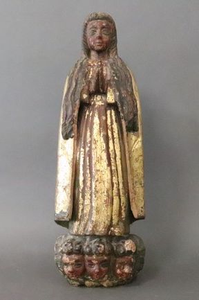 SAINTE en prière reposant sur trois masques...