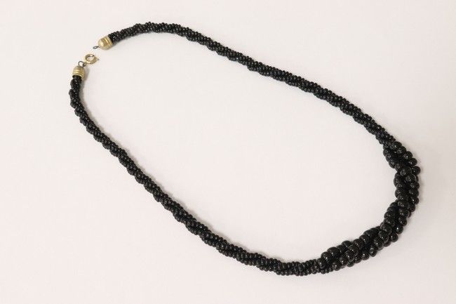 COLLIER en perles fantaisies noires entrelacées,...
