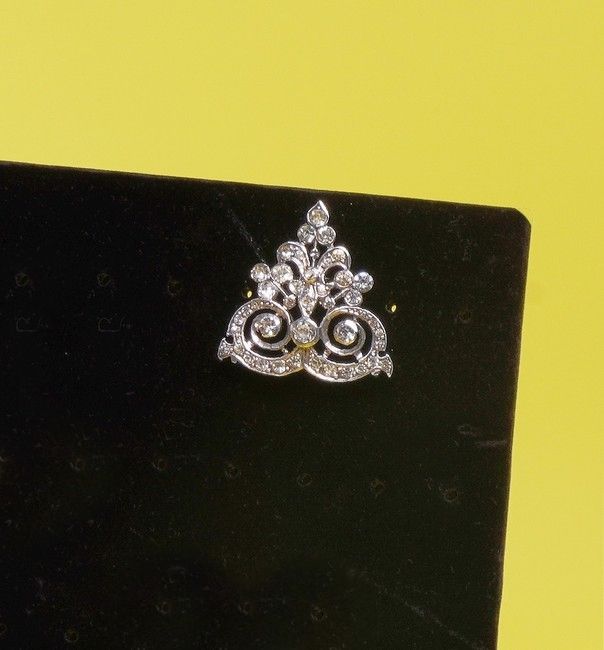 BROCHE formant boucle en argent (925) à décor...