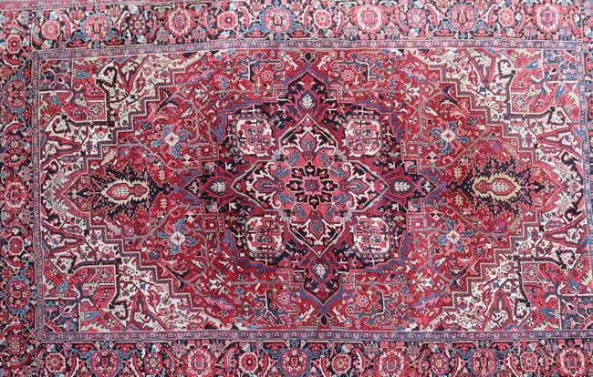 TAPIS en laine à fond rouge à décor floral...