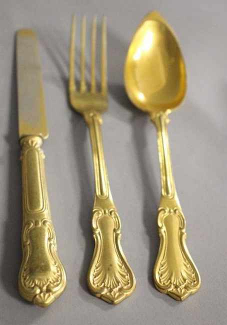 MÉNAGÈRE en métal doré à décor rocaille monogrammée...