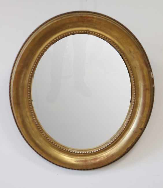 MIROIR ovale dans un cadre en bois doré à...