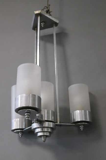 LUSTRE droit en métal chromé, à quatre lumières...