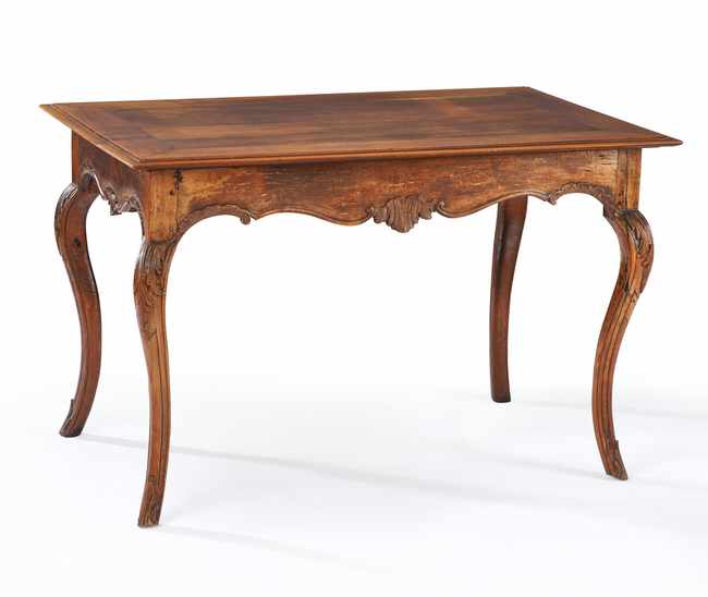 TABLE A JEU en noyer mouluré et sculpté à...