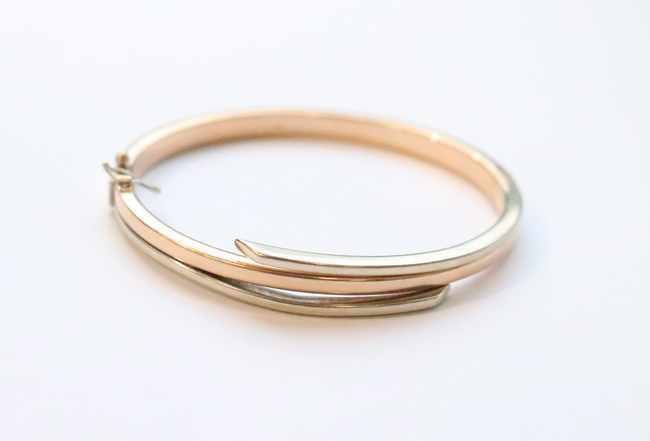 BRACELET rigide articulé en or deux tons...
