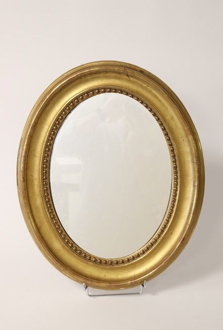 MIROIR ovale dans un cadre en bois doré à...