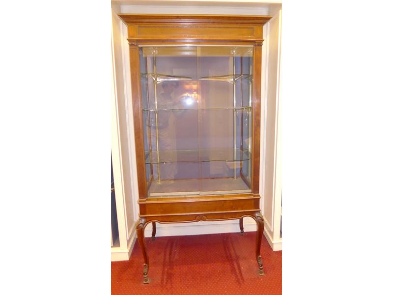VITRINE en acajou sculpté, sur quatre pieds...