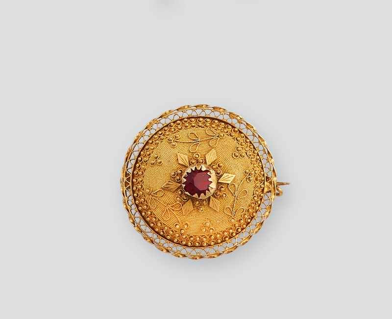 BROCHE rosace en or (750) et verre rouge...