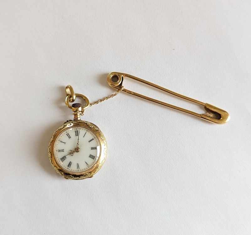 EPINGLE DE NOURISSE en or (750) et sa MONTRE...