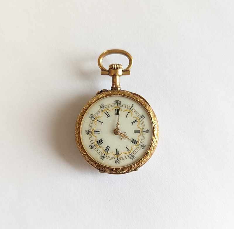 MONTRE DE COL en or jaune (750) à décor ciselé...