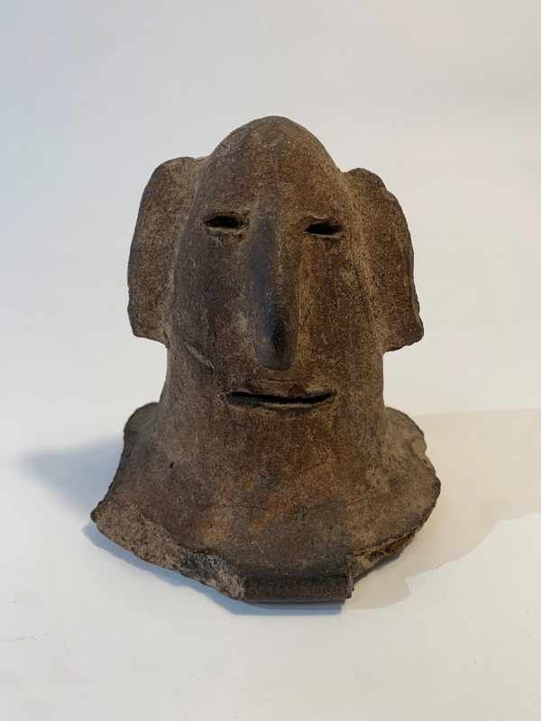 TÊTE en terre cuite avec yeux et bouche incisés,...