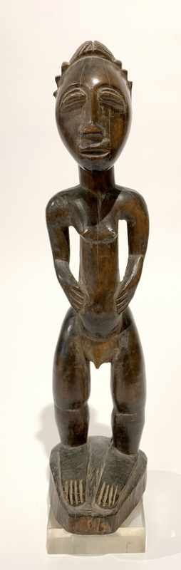 STATUETTE aux yeux mi-clos se tenant debout...