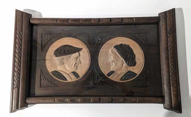 PLATEAU en bois sculpté à décor de deux profils...