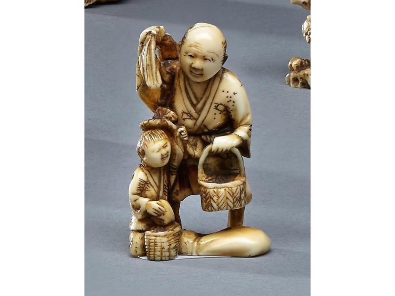NETSUKE en ivoire représentant un père et...