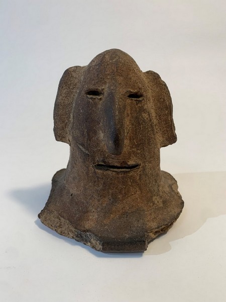 TÊTE en terre cuite avec yeux et bouche incisés,...
