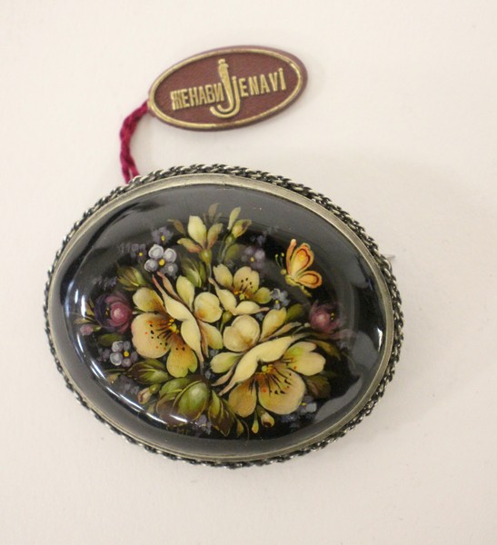 BROCHE à décor laqué d'un bouquet de fleurs...