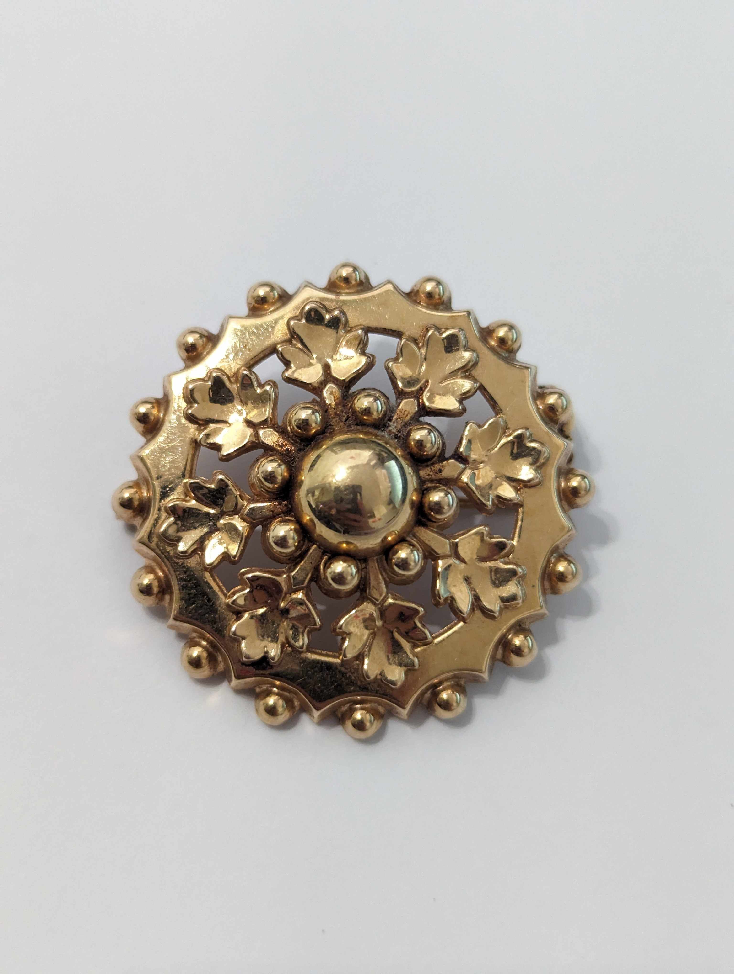 BROCHE RONDE en or jaune (750) à décor rayonnant...