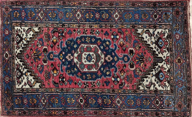 TAPIS en laine polychrome à décor d'un médaillon...