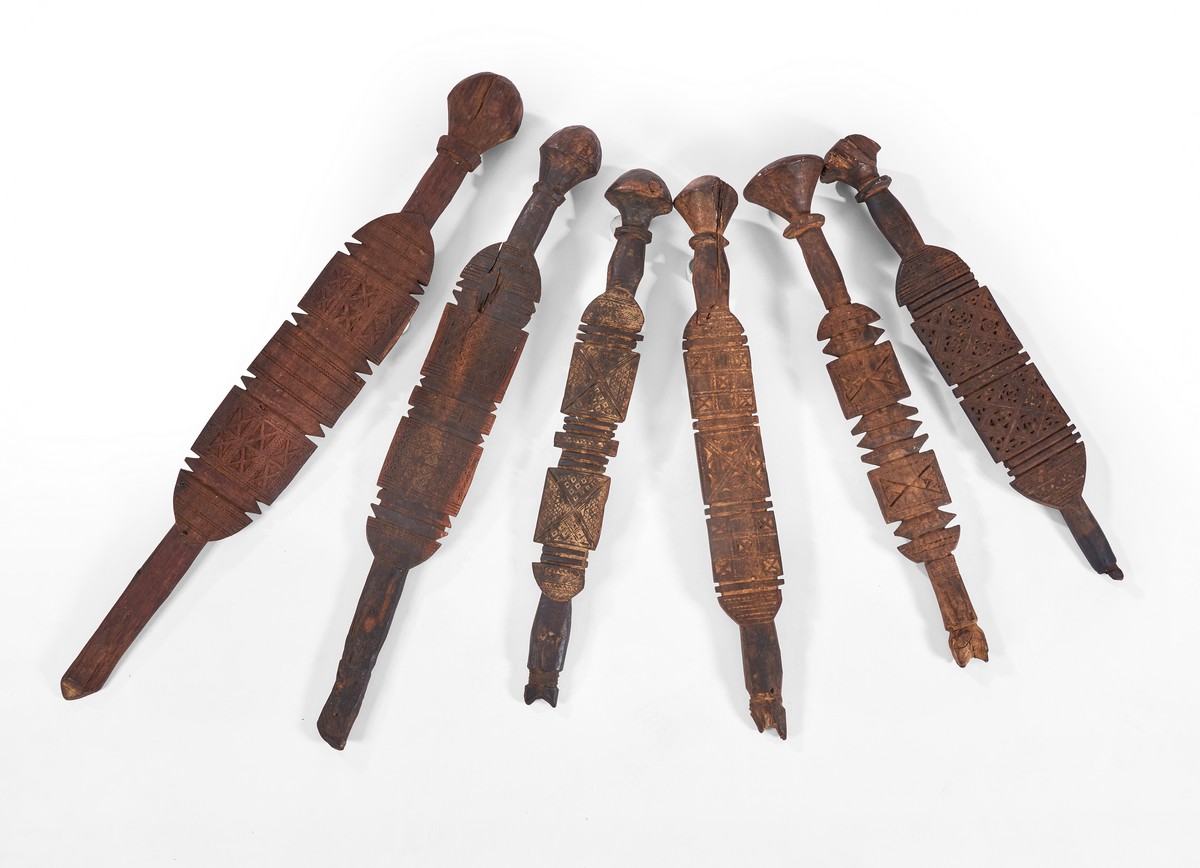 SIX PIQUETS de tente, en bois sculpté .