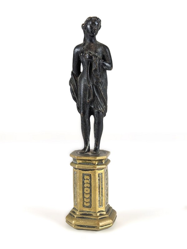 STATUETTE de femme drapée se tenant la poitrine,...