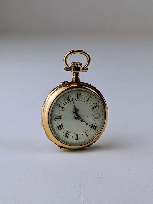 MONTRE DE COL en or (750) gravé de feuillages...