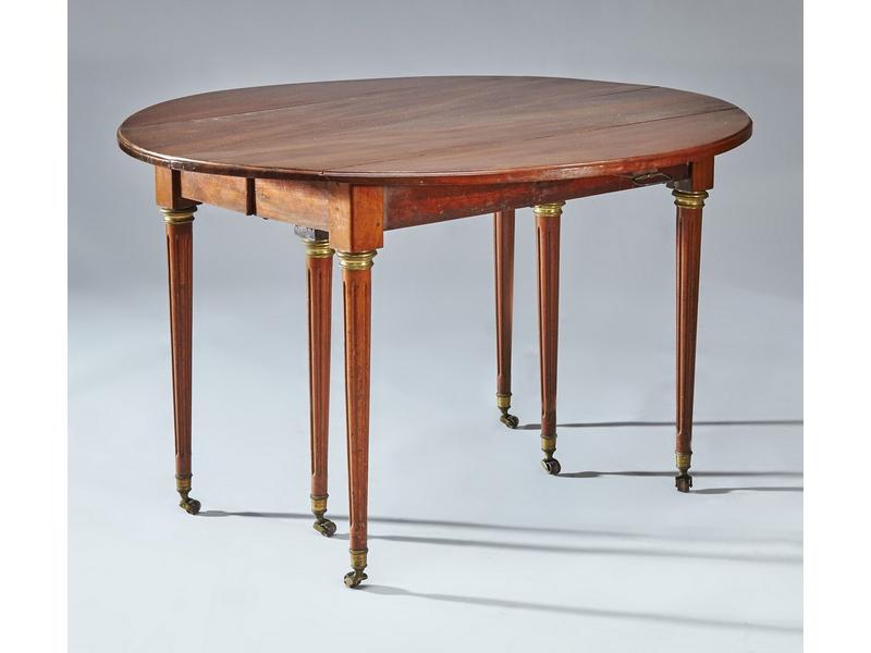 TABLE ovale à volets, en acajou, pieds cannelés...