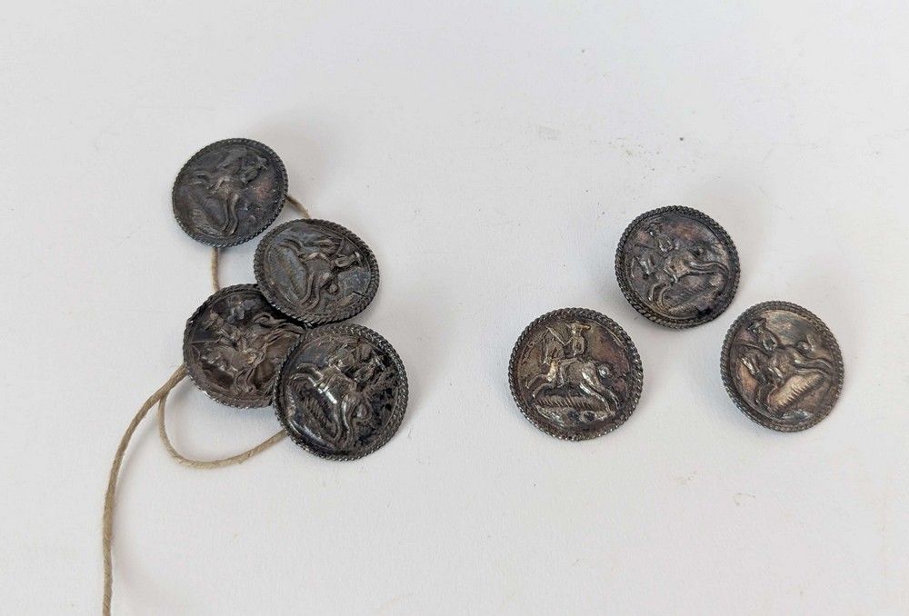SEPT BOUTONS ronds en argent à décor au repoussé...