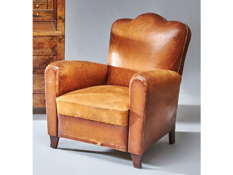 FAUTEUIL CLUB en cuir à dossier mouvementé,...