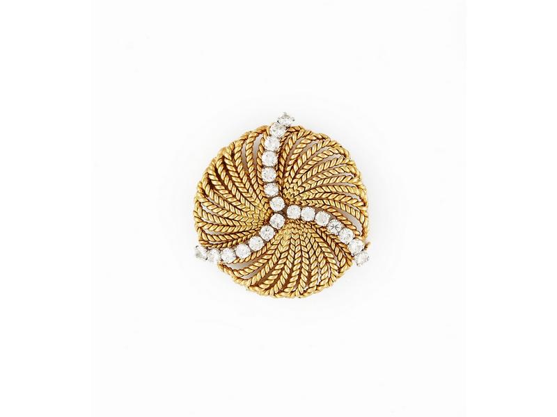 BROCHE ronde en or jaune (750) stylisant...
