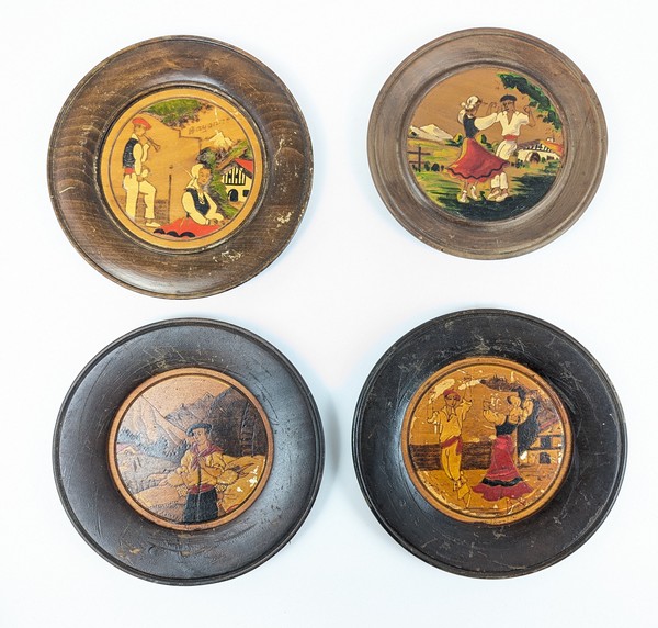 QUATRE ASSIETTES ou MÉDAILLONS en bois pyrogravé...