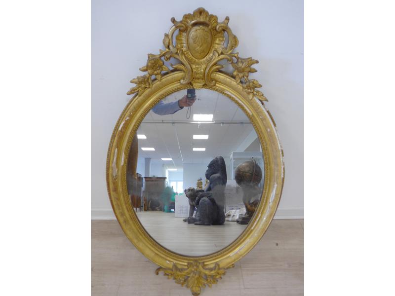 MIROIR ovale en bois et stuc doré à décor...