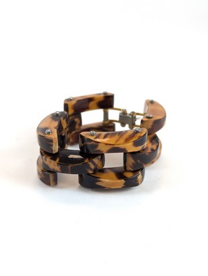 BRACELET souple en bakélite tigrée. Fermoir...