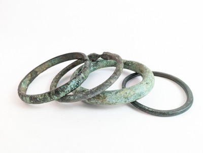 QUATRE BRACELETS en bronze à décor incisé,...