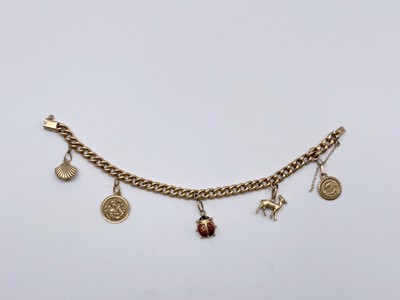 BRACELET gourmette en or (750) avec breloques...