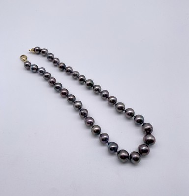 COLLIER de 34 perles noires dite de Tahiti...