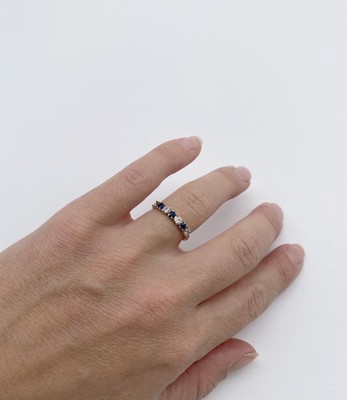 DEMI-ALLIANCE en or gris (750) à quatre petits...