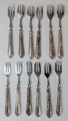 DOUZE FOURCHETTES A GATEAU à manche en argent...