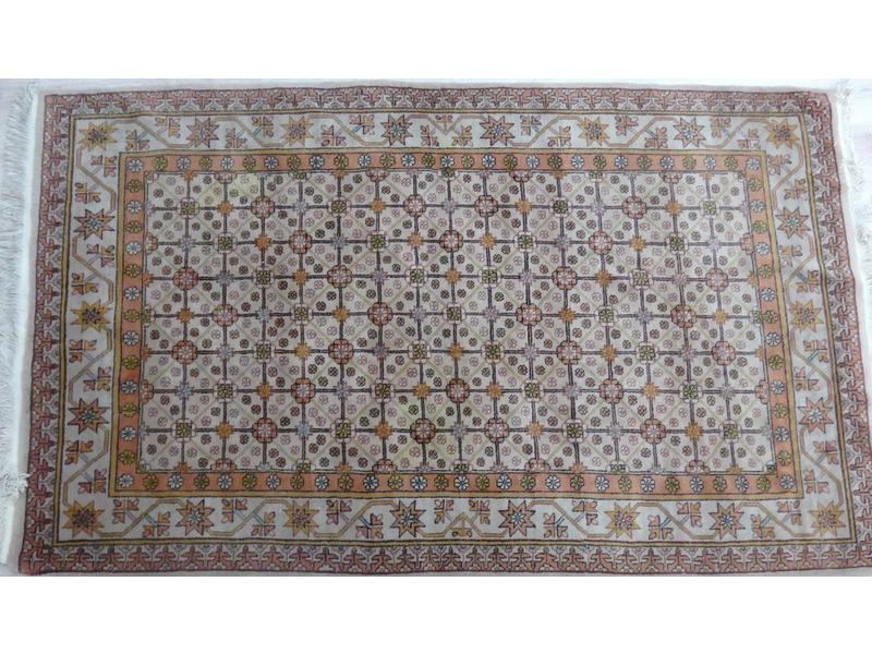 TAPIS en laine à décor dans les tons marron-rouge...