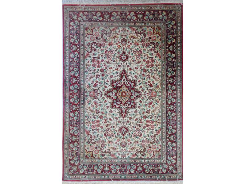 TAPIS en laine et soie à décor de rinceaux...