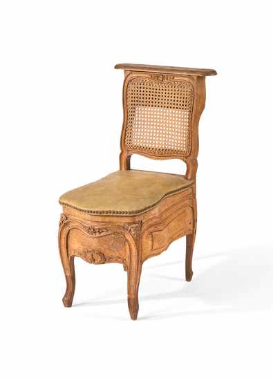 FAUTEUIL D'AISANCE en bois mouluré à assise...